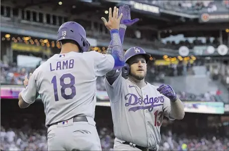  ?? Jeff Chiu Associated Press ?? MAX MUNCY, right, high-fives Jake Lamb in the second inning following Muncy’s second-inning homer in an 8-2 win at Oracle Park.