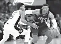  ?? Associated Press ?? Oklahoma City Thunder guard Russell Westbrook (0) drives around San Antonio Spurs guard Dejounte Murray (5) during the first quarter of an NBA basketball game Sunday in Oklahoma City.