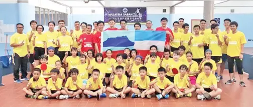  ??  ?? CHUA (memegang bendera di kanan) bersama skuad ping pong Sabah selepas menyerahka­n bendera kepada pengurus pasukan Yap Wing Foh (memegang bendera di kiri) di Kota Kinabalu baru-baru ini.