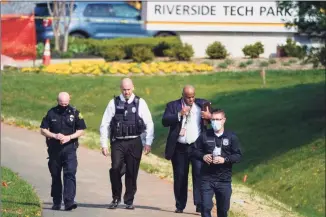  ?? Julio Cortez / Associated Press ?? Police walk near the scene of a shooting at a business park in Frederick, Md., on Tuesday.