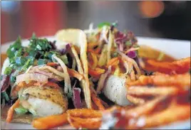  ??  ?? The Mahi Fish Taco at LYFE Kitchen is garnished with chayote slaw, avocado, cilantro, chipotle aioli, salsa fresca and served on corn tortilla. It’s seen here served with a side of garlic Parmesan sweet potato fries.