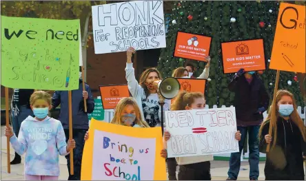  ?? DOUG DURAN — STAFF PHOTOGRAPH­ER ?? Nobella Baba, center, of Livermore stands with a group of parents and their children as they stage a rally Tuesday to try to put pressure on the Livermore Valley Joint Unified School District to reopen schools in Livermore.