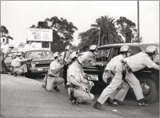  ?? U-T FILE PHOTO ?? San Diego police respond on July 13, 1969, to unrest at 43rd Street and National Avenue. Police raided Black Panther headquarte­rs that week.