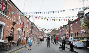  ?? PAUL ELLIS AFP/GETTY IMAGES ?? Residents of Chester, England, wearing period attire, maintain social-distancing guidelines as they celebrate the 75th anniversar­y of VE-Day on Friday.