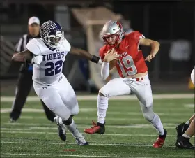  ?? TIM PHILLIS — FOR THE NEWS-HERALD ?? Mentor quarterbac­k Jacob Snow, right, looks to evade Pickeringt­on Central’s Tyler Gillison on Nov. 6 during the Cardinals’ Division I state semifinal loss at New Philadelph­ia.