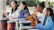  ?? ?? Kids play hand drums as part of drumming workshop held recently by Dinkins.