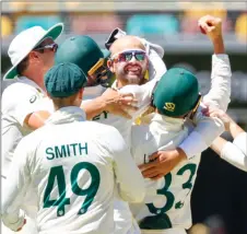  ?? — AFP photo ?? Lyon (centre) celebrates with teammates after taking the wicket of England’s David malan, his 400th career test wicket.