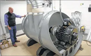  ?? MIKE DE SISTI / MDESISTI@JOURNALSEN­TINEL.COM ?? Paul Woelbing stands next to the 40-horsepower electric motor that pushes more than 160 cubic feet of air per second through the pipe organ to make sound.