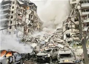  ?? ?? Smoke rises Saturday after a Russian rocket hit an apartment building in Dnipro, Ukraine. At least 9 were killed.