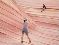  ??  ?? The rock formation known as The Wave, in the Arizona backcountr­y near the Utah border, is a photograph­er’s paradise with dramatic contours in bright orange, red, pink and yellow.