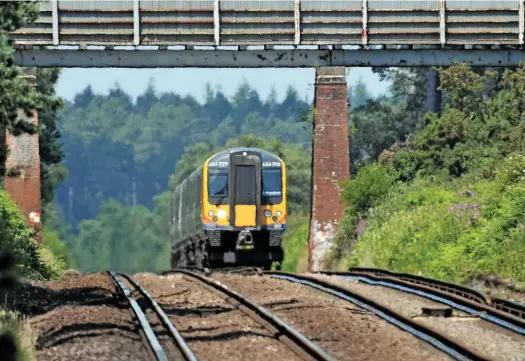  ?? MARK PIKE. ?? On a very hot July 5 2013, the heat haze rises from the tracks as South West Trains 444029 approaches Beaulieu Road with a Waterloo-Weymouth service. During periods of high temperatur­es, Network Rail introduces temporary speed restrictio­ns as a safety measure.