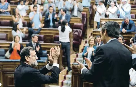  ?? EMILIO NARANJO / EFE ?? Mariano Rajoy aplaude al grupo popular, mientras Pablo Iglesias, al fondo, hace lo propio con los suyos