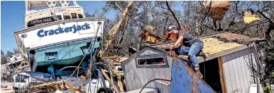  ?? ?? People clear debris in the aftermath of Hurricane Ian in Fort Myers Beach, Florida on September 30. (AFP)