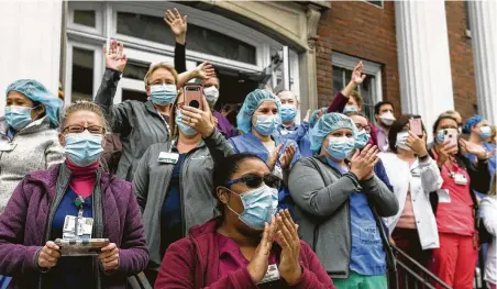  ?? Jake Danna Stevens / Associated Press ?? Hospital workers in Scranton, Pa., cheer as a First Responders Appreciati­on Parade passes by on Wednesday for National Nurses Week. Health experts are expressing growing dread over what they say is an all-but-certain second wave of deaths and infections.