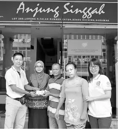  ??  ?? Wan (left) presents the donation to the couple (second and third right) recently while Anjung Singgah officials look on.