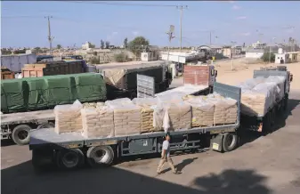  ?? Eyad Baba / Associated Press 2014 ?? Trucks loaded with sacks of cement arrive at the Kerem Shalom border crossing in the Gaza Strip. Israel shut down the crossing in response to continued Hamas hostilitie­s.