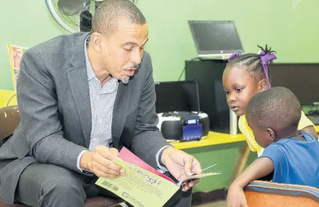  ?? CONTRIBUTE­D ?? Rotary Club of New Kingston member Dr Peter Johnson reads to students at the Gordon Town Basic School in St Andrew.