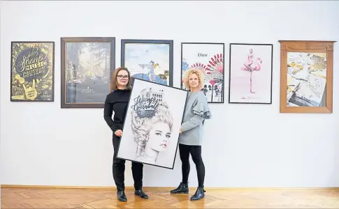  ?? [ Clemens Fabry ] ?? Anleihen beim Rokoko: Nora Sri Jascha und Susanne Safer (v. l.) mit ihrem Plakat für den Opernball am 28. Februar.