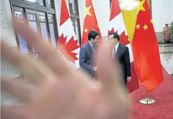  ?? SEAN KILPATRICK/THE CANADIAN PRESS ?? A security guard attempts to block a photograph­er as a picture is taken of Prime Minister Justin Trudeau being greeted by Chinese Premier Li Keqiang at the Great Hall of the People in Beijing, China on Monday The incident happened following a...