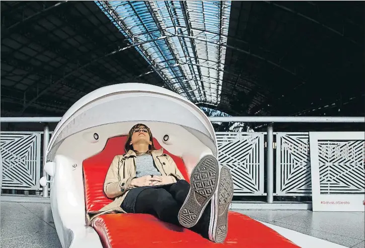  ?? DANI DUCH ?? Una mujer descansa en una Siestesill­a, una confortabl­e tumbona instalada en la estación de Atocha por un buscador de hoteles para reivindica­r la siesta