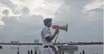  ?? ?? A traffic policeman makes an announceme­nt as part of precaution­ary measures against Cyclone Asani, on banks of Ganga river, in Kolkata, on Tuesday.