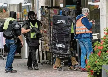  ?? Foto: dpa ?? Mit Matten geschützt – so suchen Polizisten in der Innenstadt von Schaffhaus­en nach dem Angreifer.