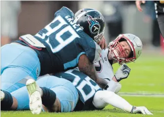 ?? AUSTIN ANTHONY THE ASSOCIATED PRESS ?? New England Patriots quarterbac­k Tom Brady is sacked by Tennessee Titans defensive end Jurrell Casey (99) and linebacker Harold Landry on Sunday in Nashville. Brady was sacked three times in the game.