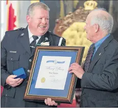  ?? CP PHOTO ?? Bruce Knocton, from Milford, N.S., chats with Hugh Laurence, chair of the Medal of Bravery advisory committee, right, in Halifax on Tuesday. Knocton, a deputy with the Nova Scotia Sheriff Services, helped save a woman trapped in her burning car after a head-on collision and was awarded a Medal of Bravery. Also recognized were Paul Rowe of Chester Basin, Jules Dufour of Halifax and Kevin Tough of West Pennant.
