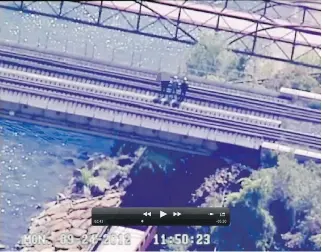  ??  COURT EXHIBIT ?? In a screengrab from a surveillan­ce video from September 2012, accused terrorist plotters Chiheb Esseghaier and Raed Jaser examine a Toronto-area railway bridge in the company of an undercover FBI agent. Esseghaier is wearing a camouflage jacket. The...