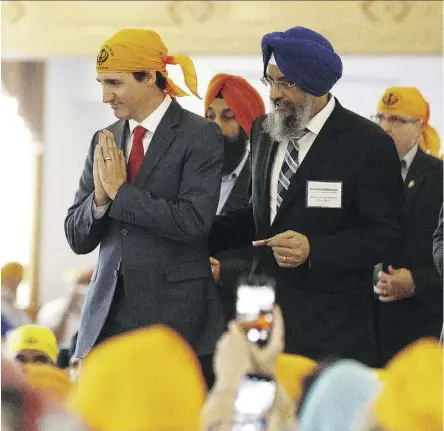  ?? IAN KUCERAK ?? Prime Minister Justin Trudeau with Gurdwara Millwoods president Karnail Singh Bhamra Monday during a visit to the temple, where he donated food to a food bank, prayed and served a meal to temple members.