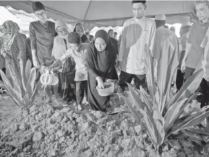  ?? — Gambar Bernama ?? TABUR BUNGA: Siti Nur Syafiqa menabur bunga ke pusara Allahyarha­m Zainal Abidin di Tanah Perkuburan Masjid Jamek Sungai Acheh, Nibong Tebal, semalam.