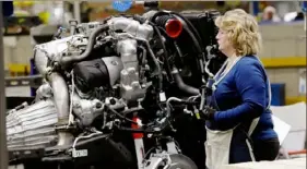  ?? Jeff Kowalsky/AFP via Getty Images ?? Line workers work on the chassis of full-size General Motors pickup trucks at the Flint Assembly plant in 2019. GM said on Thursday that it would pause production at eight North American plants during the next two weeks because of a global shortage of computer chips.