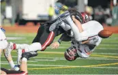  ?? Kin Man Hui / Staff photograph­er ?? Luke Termin flips Sam Houston State QB Ty Brock upside down to force a fumble in UIW’s 43-26 win last week. The Cardinals can clinch a share of the conference title by beating Central Arkansas today.