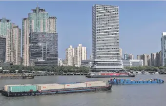  ?? ?? Contenedor­es circulan por el río Huangpu, en Shanghái, China, principal puerto de suministro.