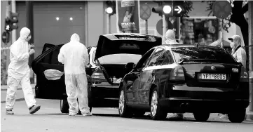  ??  ?? Forensic officers inspect the car of Papademos following the detonation of an envelope injuring him and his driver, in Athens, Greece. — Reuters photo