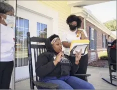  ?? Veasey Conway / New York Times ?? Zy’keya Johnson, 13, center, speaks with teacher Raven Cole, right, during an exercise in Whitakers, N.C. Concerns are being raised about the impact of remote learning.