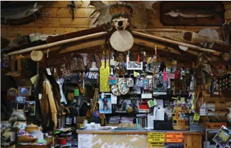  ??  ?? Among the treasured parapherna­lia lining the walls and ceiling of Robertson Trading Co. (left) is a painting of Alex Robertson, the store’s first owner (above).