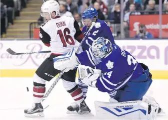  ?? FRANK GUNN, THE CANADIAN PRESS ?? Maple Leafs goaltender James Reimer makes a save as Leafs defenceman Matt Hunwick battles in front with Coyotes forward Max Domi on Monday.