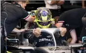  ?? PAUL CHIASSON — THE CANADIAN PRESS VIA AP ?? Mercedes Team driver Lewis Hamilton, of Britain, slips into this car during the first practice session at the Formula One Canadian Grand Prix auto race Friday in Montreal.