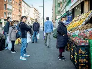  ??  ?? Per strada
I cittadini in coda a un fruttivend­olo di via Padova (foto Ansa/ Marco Passaro)