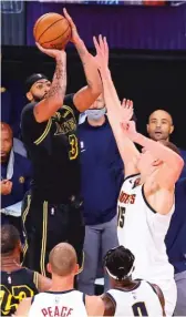  ?? KEVIN C. COX/GETTY IMAGES ?? The Lakers’ Anthony Davis launches the winning three-pointer over the Nuggets’ Nikola Jokic on Sunday in Orlando, Fla.