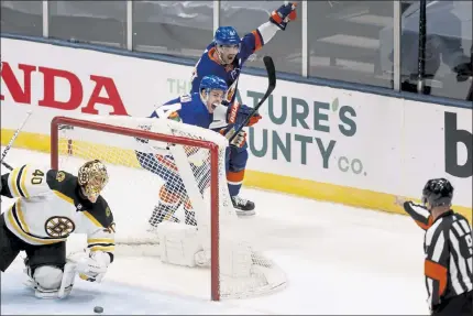  ?? JASON DECROW PHOTOS /AP ?? New York Islanders' Jean-Gabriel Pageau (44) celebrates with teammate Cal Clutterbuc­k after scoring on Bruins goalie Tuukka Rask during the third period of Monday’s game in Uniondale, N.Y.