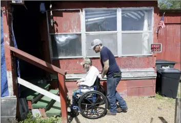  ?? MARK HUMPHREY — THE ASSOCIATED PRESS ?? In this photo, Johnny Gibbs helps his disabled father, Mike, 65, into their home in Liberty, Tenn. Johnny Gibbs has been trying to get a valid driver’s license for 20 years, but he can’t afford it. To punish him for high school truancy in 1999, Tennessee suspended his ability to get a license until he turned 21. When Gibbs couldn’t pay for traffic violations, he ended up serving jail time and probation. But rather than wiping his fines and allowing him to obtain a valid license, he wound up even more deeply in debt because he had to pay a monthly supervisio­n fee to a private probation company.