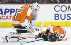  ?? Derik Hamilton/Associated Press ?? Philadelph­ia Flyers goalie Petr Mrazek, left, looks over injured teammate Ivan Provorov after Provorov blocked a shot in the first period Thursday against the Carolina Hurricanes.