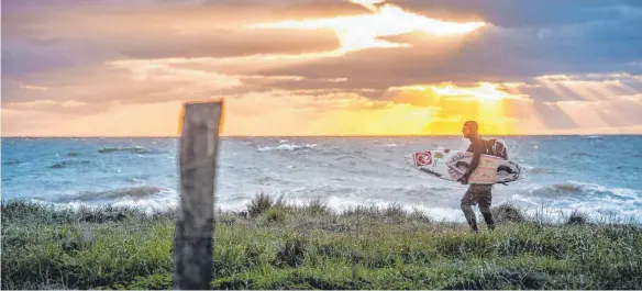  ?? FOTOS: DPA ?? Ab in die Wellen: Da auf Fehmarn fast immer Wind weht, ist die Insel bei Surfern beliebt, auch im Winter.