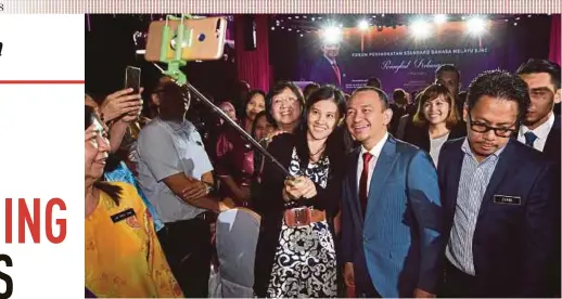  ?? BERNAMA PIC ?? Education Minister Dr Maszlee Malik taking a selfie with an attendee after officiatin­g at the National SJKC Bahasa Melayu Improvemen­t Forum at HGH Convention Centre in Kuala Lumpur yesterday. With him is Deputy Education Minister Teo Nie Ching (behind Maszlee).