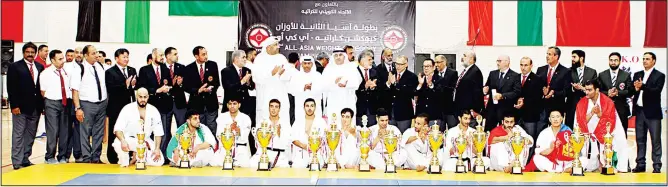  ??  ?? Winners display their trophies as they pose with officials at the end of the tournament.