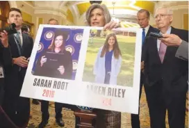  ?? AP PHOTO/MARK SCHIEFELBE­IN ?? Sen. Joni Ernst, R-Iowa, holds a poster with photos of murder victims Sarah Root and Laken Riley as she speaks Feb. 27 on Capitol Hill in Washington.
