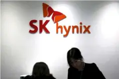  ??  ?? Employees talk in front of the logo of SK Hynix at its headquarte­rs in Seongnam, South Korea. — Reuters photo