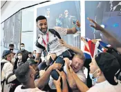  ??  ?? Right, cyclists Laura Kenny, Jason Kenny and Katie Archibald, front row, lead Team GB as the Olympians arrive back at Heathrow airport from Japan yesterday. Above, gold medal-winning boxer Gamal Yafai, is mobbed by fans